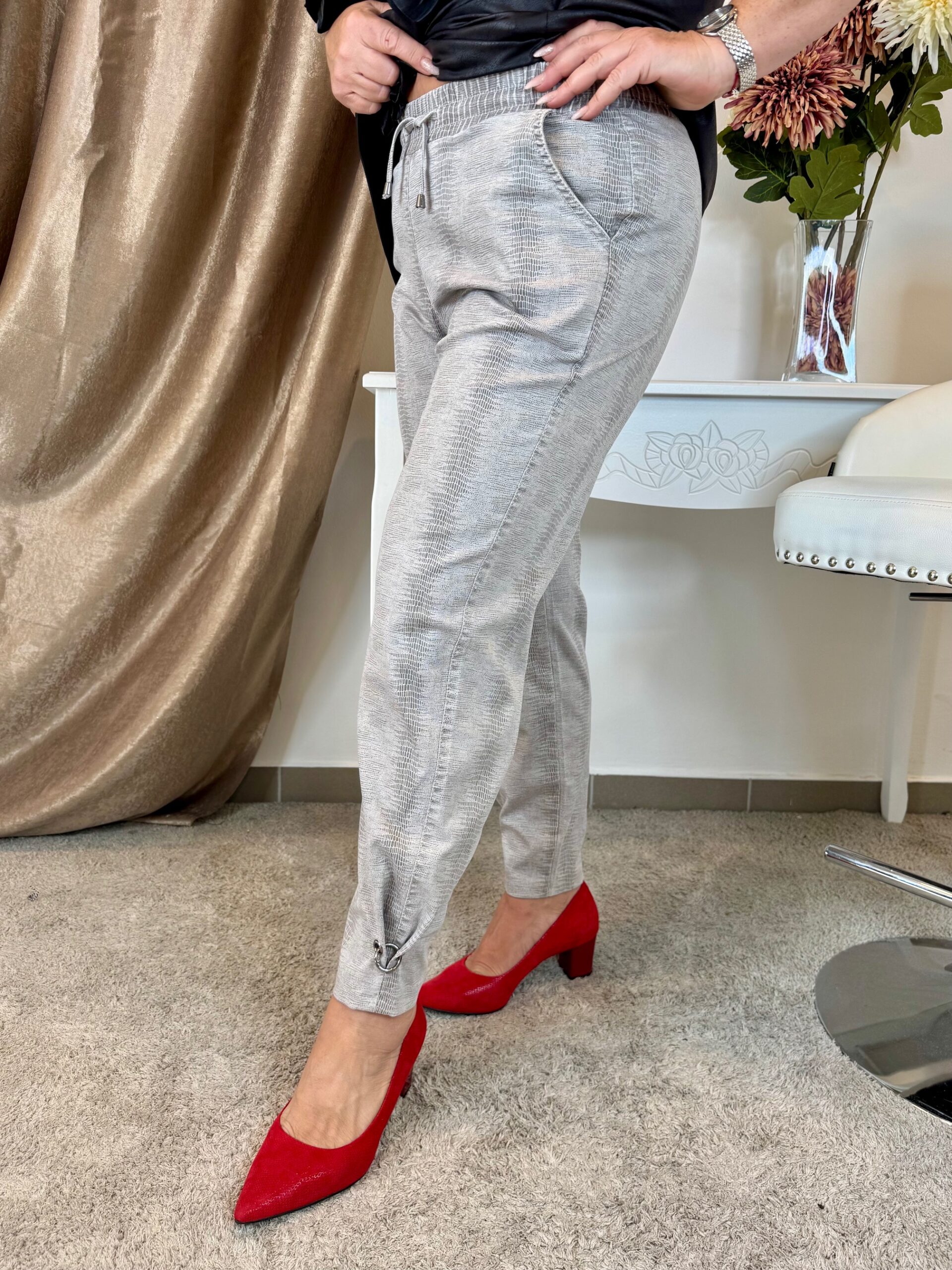 Szürkés bézs gumis derekú kígyómintás farmer bokáján fém karikával