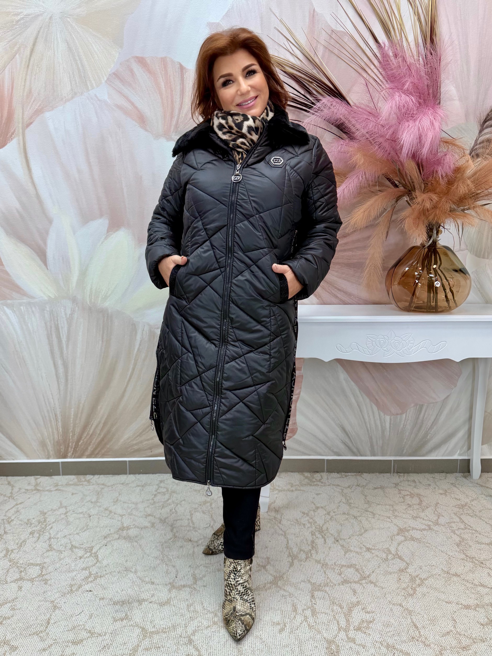 Hosszú fekete steppelt kabát szőrmegallérral